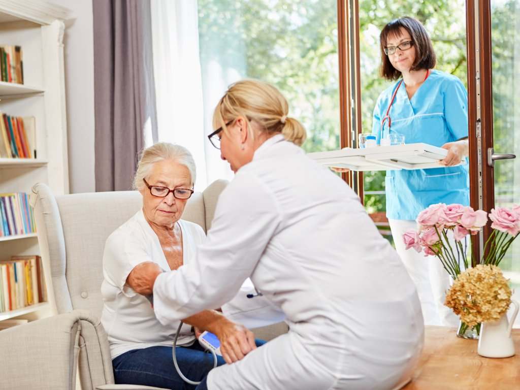 Enfermeras con persona mayor tomando la tensión